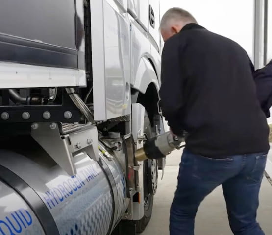 Man loading a hydrogen refill onto a truck