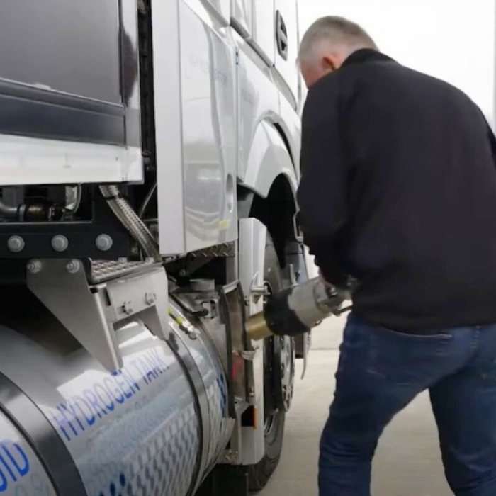 Homme en train de recharger un camion à hydrogène liquide sur une station de remplissage