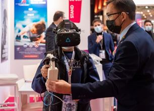 Young person using virtual reality next to a man 