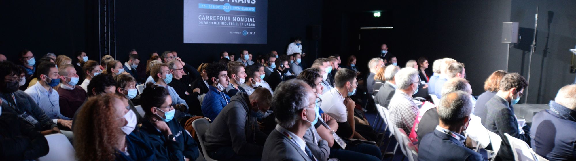 Grand groupe de personnes assises participant à une conférence